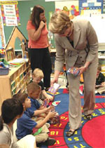 Education Secretary Spellings hands out books to the children.