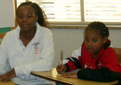 Two of the children from C.U.D.D.L.E.S. who receive books.