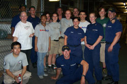 Coast Guard volunteers pose with First Book staff members in a warehouse.